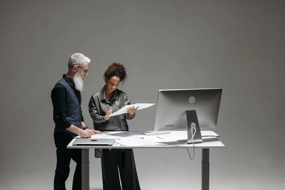 An open-plan office where people are working at adjacent desks, suggesting a team coordinating its work across a shared surface