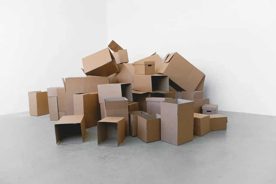 Stacked cardboard moving boxes in a bright empty office, ready for a relocation