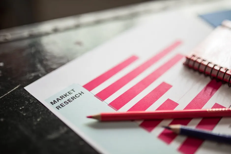Printed market-analysis charts and data spread across a desk beside a laptop, suggesting a market opportunity being assessed before a build decision