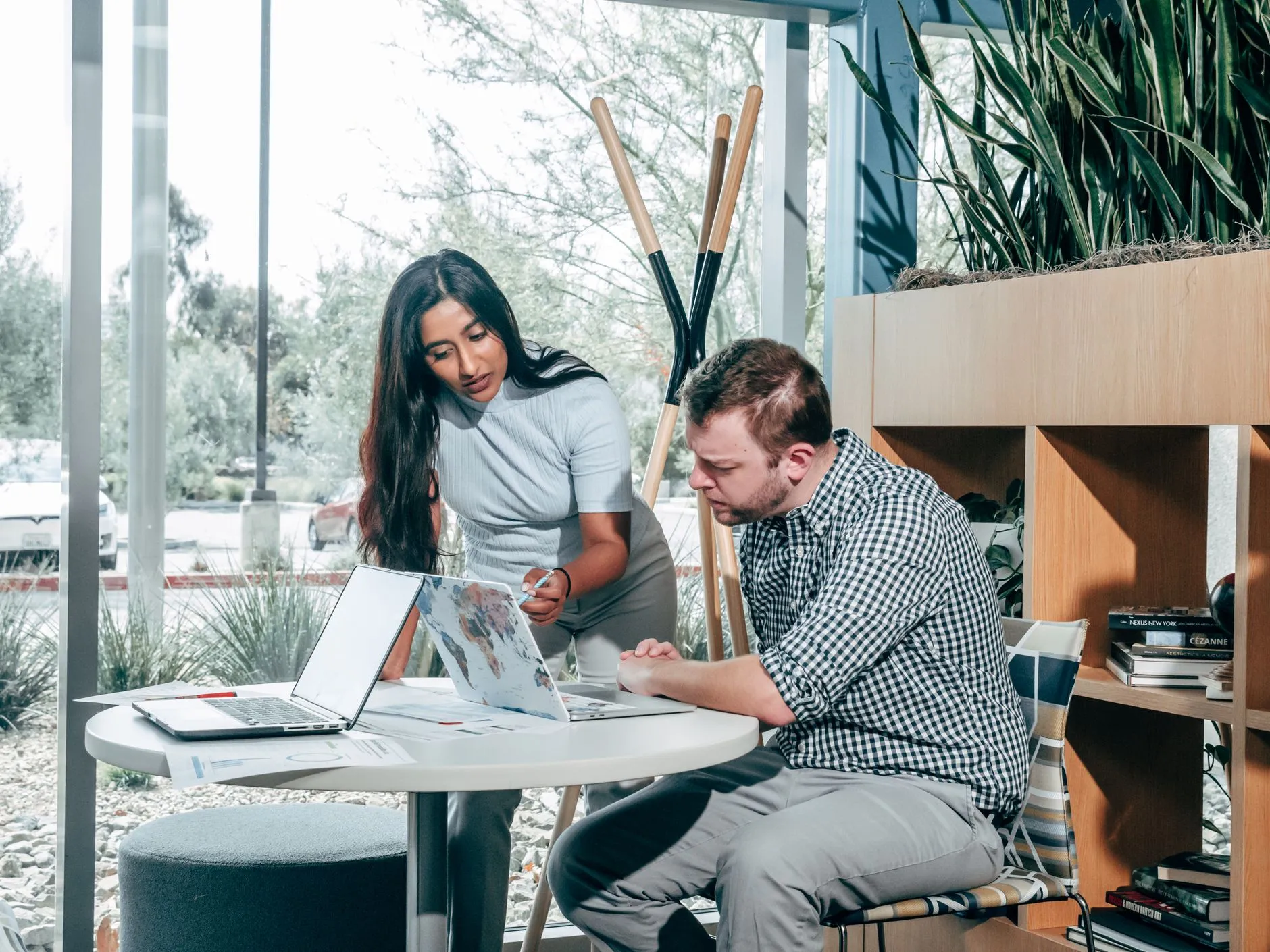 Two people at a desk planning a project together on a laptop
