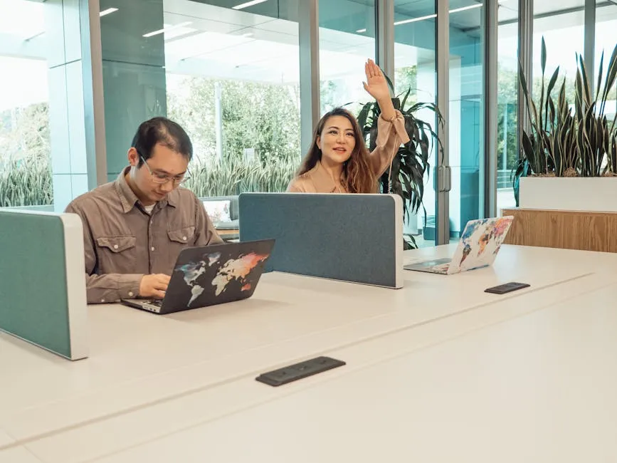 An open-plan office floor with rows of desks and people working at laptops, suggesting the internal workforce a corporate intranet serves